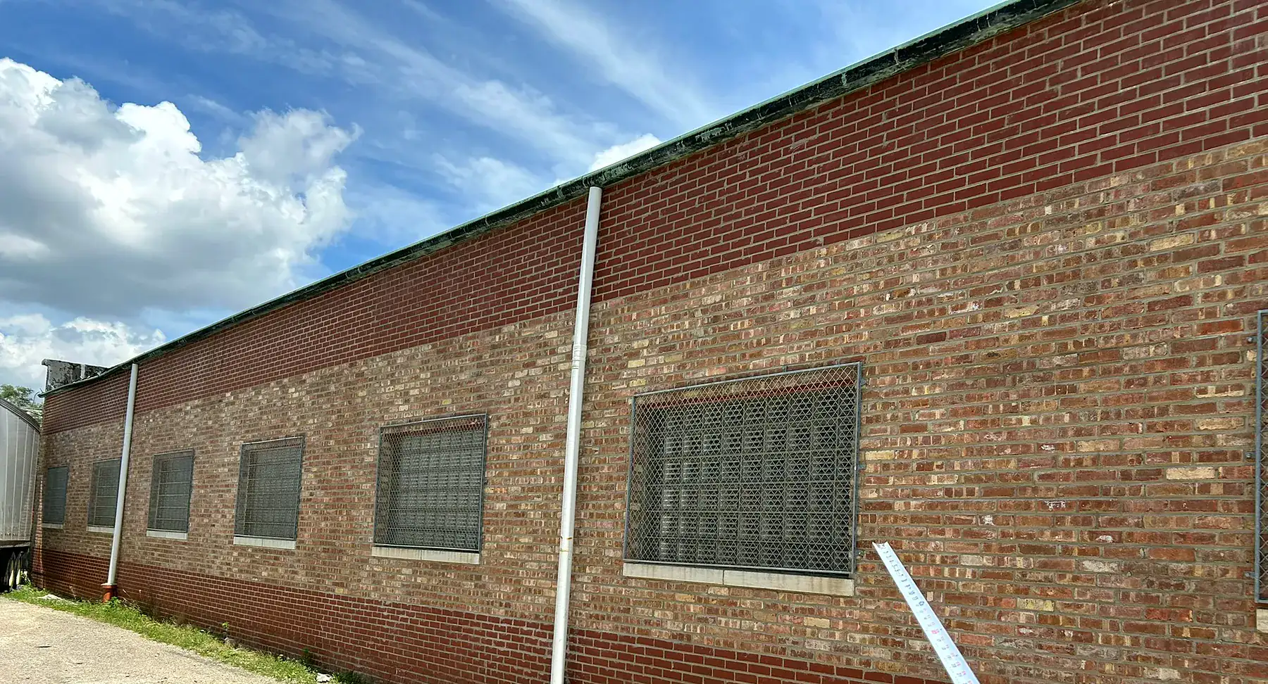 Commercial warehouse brick wall after full-height tuckpointing by Emerald Masonry LLC